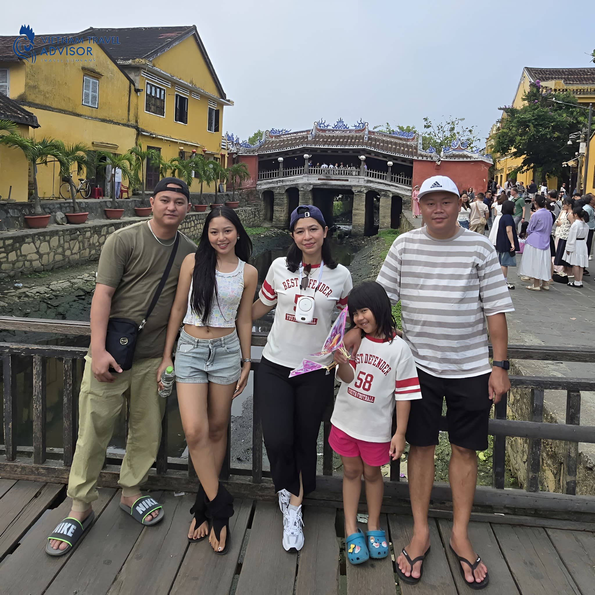 Family travelers walking through Hoi An heritage town in Vietnam.